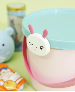 Close-up of pink plastic candy box with blue lid and a cute white rabbit decoration