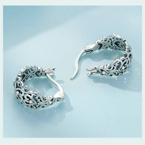 Macro shot of silver vintage hollow earrings with sparkling cubic zirconia inlay