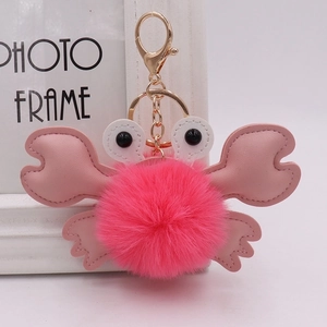 Pink plush crab keychain with furry pompom, leather claws and golden metal clasp