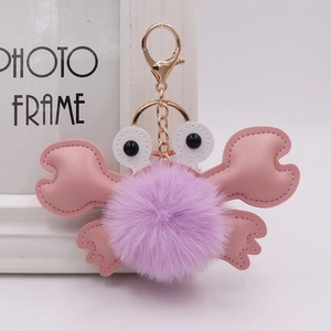 Detail of cute plush crab keychain with purple faux fur ball and pink faux leather legs