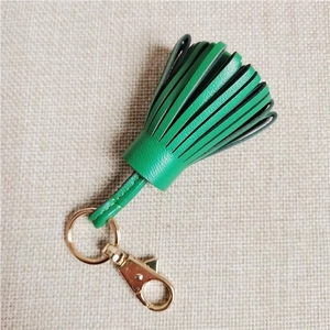 Detailed close-up of green sheepskin leather tassel pendant with golden lobster clasp