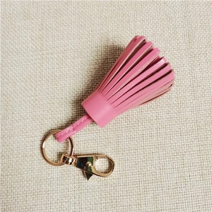 Close-up of pink sheepskin leather tassel pendant with gold lobster clasp and keyring