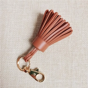 Close-up of caramel sheepskin leather tassel charm with gold lobster clasp for bags