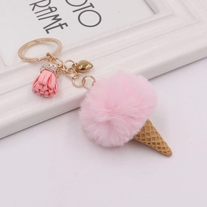 Detailed shot of plush pink ice cream cone keychain with gold ring and tassel charm