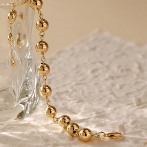 Polished 14K gold plated bead chain bracelet featuring a lobster clasp and modern aesthetic