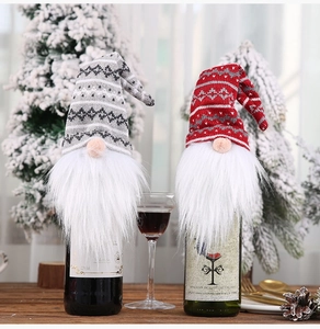 Close-up of gray and red knitted gnome wine bottle covers with white Nordic patterns
