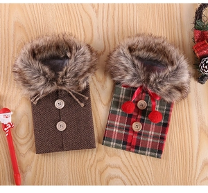 Detail of Christmas wine bottle covers with faux fur collars and festive plaid patterns
