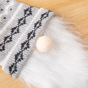 Close-up of a Christmas gnome bottle topper with a knitted hat and long white beard