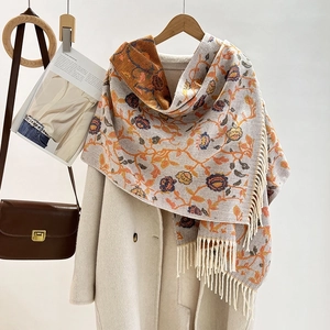 Detailed view of the jacquard floral pattern and tassels on a thick winter scarf