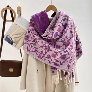 Close-up of jacquard floral scarf with fringes styled on a warm beige winter coat