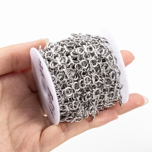 Silver stainless steel four-leaf clover chain on a white spool for DIY jewelry making