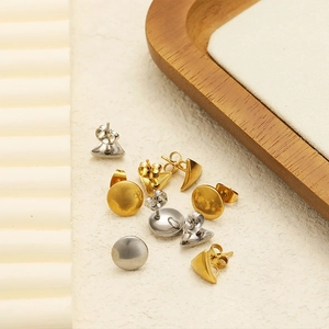 Minimalist 18K gold and silver geometric triangle stud earrings on textured background