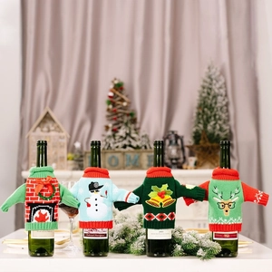 Detail view of 4 festive knitted Christmas wine bottle covers with reindeer and snowman designs