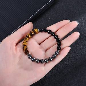 Triple bead bracelet with tiger eye, obsidian, and hematite on a leather background
