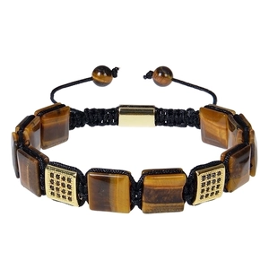 Macro shot of tiger eye stone bracelet with gold accents and black braided cord