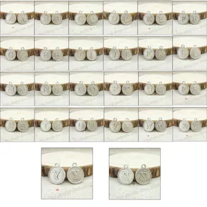 Macro detail of vintage silver alphabet charms from A to Z with antique finish