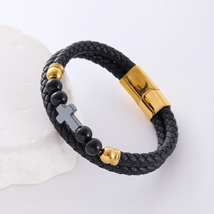 Double-layered black leather bracelet with gold beads and a grey cross on stone prop