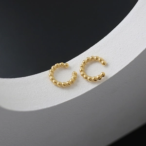 Close-up of golden beaded C-shaped ear cuff with textured 18K gold plated steel spheres