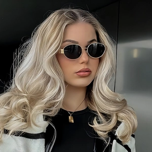 Retro oval metal sunglasses with gold frame and dark lenses worn by a model in profile
