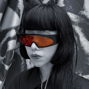 Retro oversized shield sunglasses with black frames and vibrant orange lenses worn by model