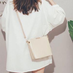 Chic cream white bucket bag with gold hardware and slim strap for daily commute
