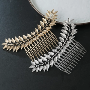 Macro detail of gold and silver hollow leaf metal hair combs with intricate vein textures