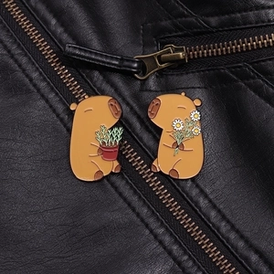 Close-up of capybara enamel pins with flower and plant on a black leather jacket