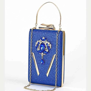 Detail van blauwe avondtas met strass-steentjes, goudkleurig handvat en kristalaccent
