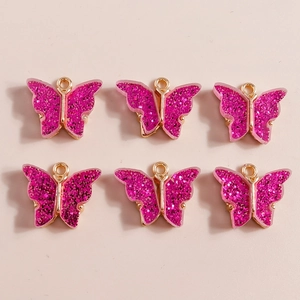 Close-up of six pieces of bright rose pink glitter butterfly DIY charms with gold edges