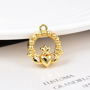 Macro shot of a golden brass Claddagh heart pendant with crown for DIY jewelry making
