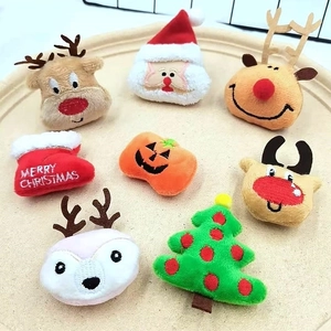 Macro view of plush Christmas charms including Santa and reindeer on wooden tray