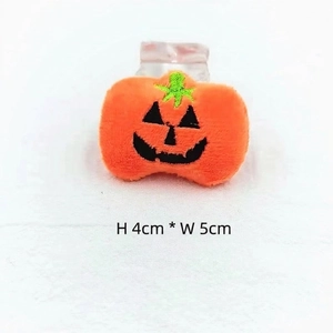 Detail of a 4x5cm plush Halloween pumpkin accessory with a smiling face and hair clip