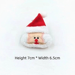 Detail view of plush Santa Claus accessory with embroidery, size 7cm height by 6.5cm width