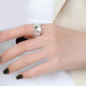 Irregular silver molten lava ring with hammered texture worn on a female finger