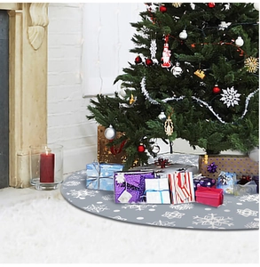 Close-up of grey Christmas tree skirt with white snowflake patterns in a cozy festive room