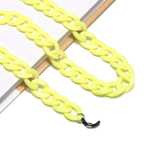 Detail of bright yellow acrylic glasses chain with black rubber loops on white background
