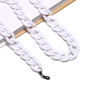 Macro shot of chunky white acrylic eyewear chain with adjustable rubber loops on a notebook