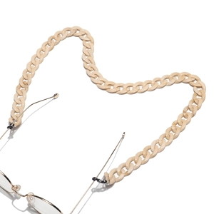 Macro shot of cream acrylic link glasses chain arranged in a heart shape on white