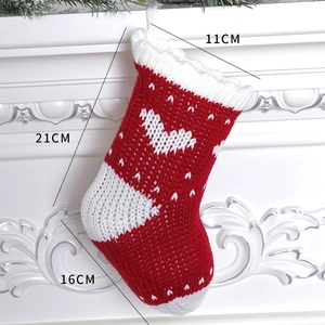 Close-up of red and white knit Christmas stocking with heart pattern and size measurements