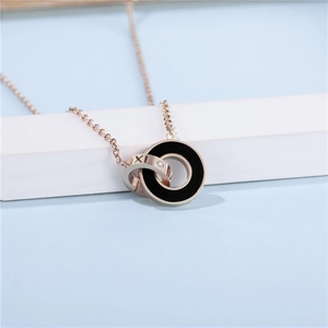 Gros plan du pendentif double anneau or rose et noir avec chiffres romains et gemme