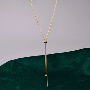 Detail of adjustable rose gold Y-necklace featuring a sliding bead and smooth metal texture