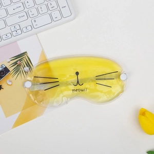 Yellow cat-shaped cooling gel eye mask with meow pattern on a white work desk
