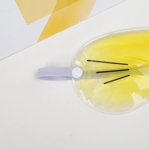 Reusable yellow gel eye mask with adjustable strap for cooling and heat therapy