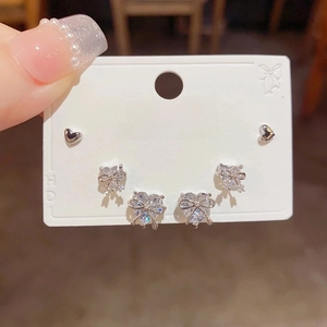 Three-piece silver earring set featuring zircon bow and minimalist heart studs