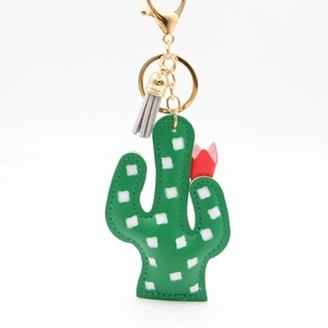 Porte-clés cactus en cuir vert avec pois blancs et pompon gris sur fond blanc
