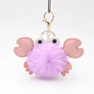 Detail of purple fluffy crab keychain with pink PU leather claws and gold metal clip