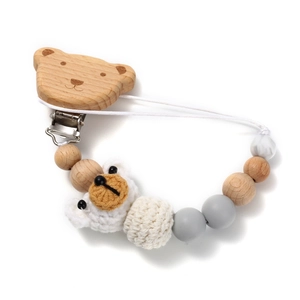 Detail of crochet bear pacifier clip with natural wood and silicone beads for infants