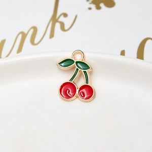 Detail shot of a red cherry alloy pendant with gold edges on white porcelain base