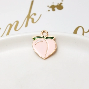 Macro shot of pink peach alloy pendant with green leaf and golden metal border