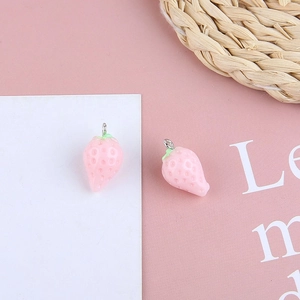 Detail of pink resin strawberry charm with green leaf and silver ring for DIY jewelry
